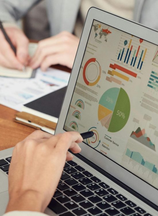 pexels-photo-3183171-3183171 Professionals engaged in a business meeting, analyzing data and charts on laptops and papers.